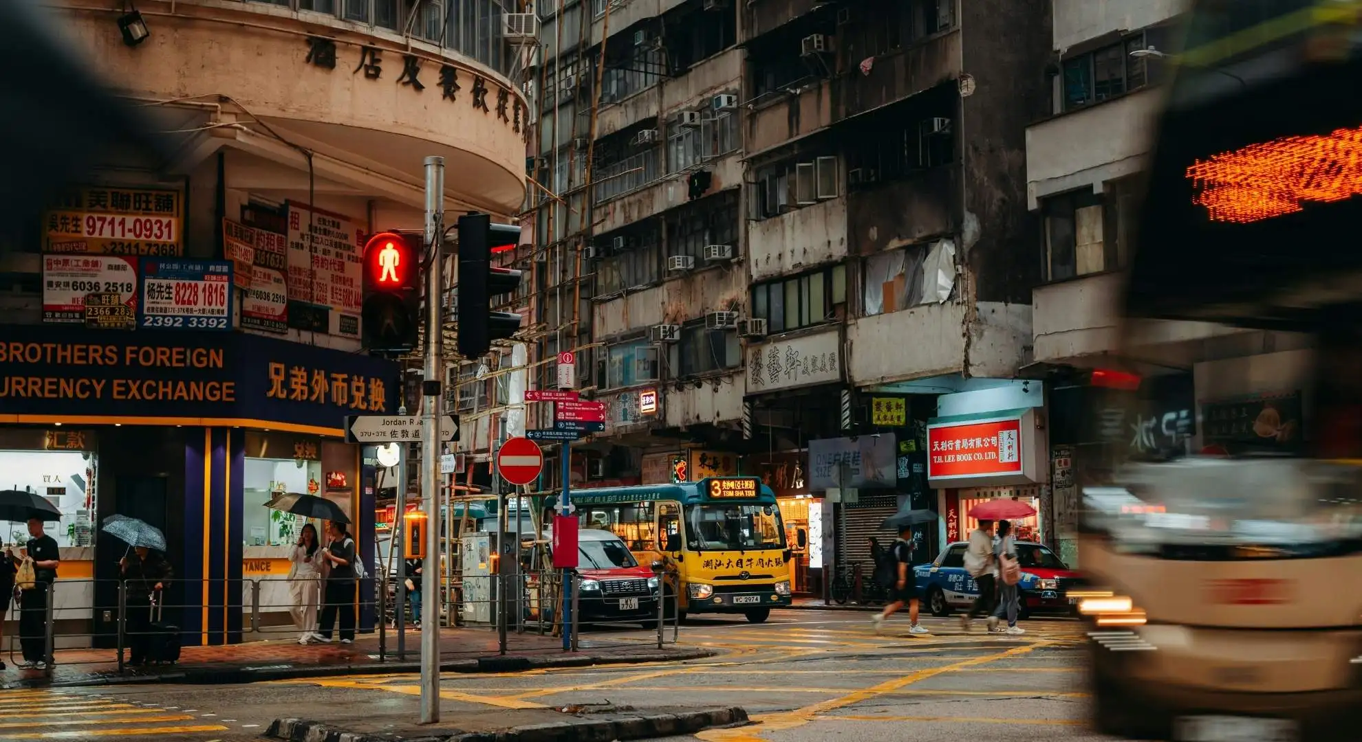 Busy street intersection in Hong Kong with neon signs and pedestrians, a gateway city for private jet charter travel