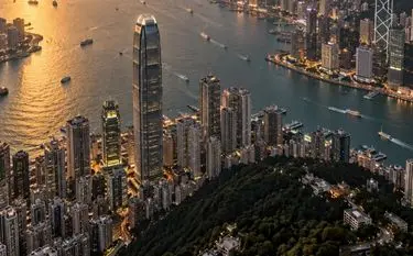 Aerial view of Hong Kong's Victoria Harbour skyline at golden hour, a premier private jet charter destination in Asia