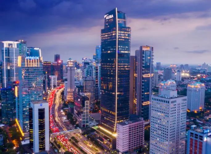 Aerial view of Jakarta's illuminated business district skyline at dusk, representing Indonesia private jet charter