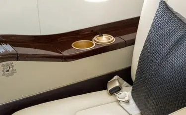 Private jet cabin interior detail showing premium leather seat, highlighting onboard comfort unavailable in business class