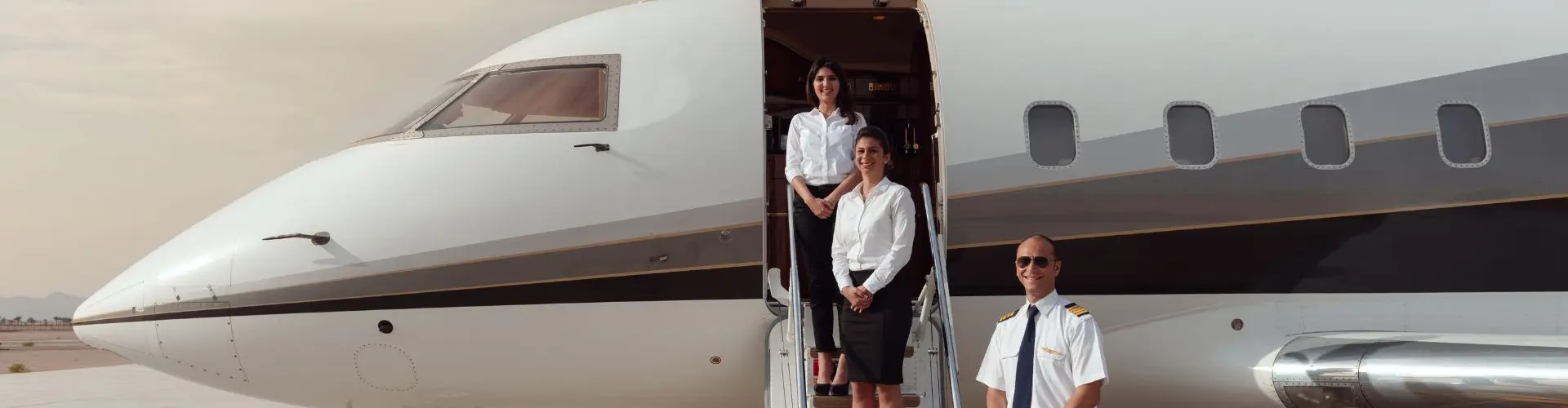Private jet crew standing at the airstairs of a business jet on the tarmac for a private charter flight in Indonesia