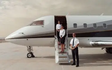 Private jet crew standing at the airstairs of a business jet on the tarmac for a private charter flight in Indonesia
