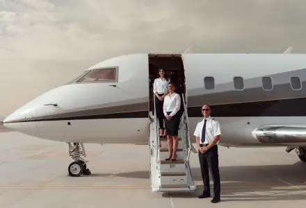 Private jet crew standing at the airstairs of a business jet on the tarmac for a private charter flight in Indonesia