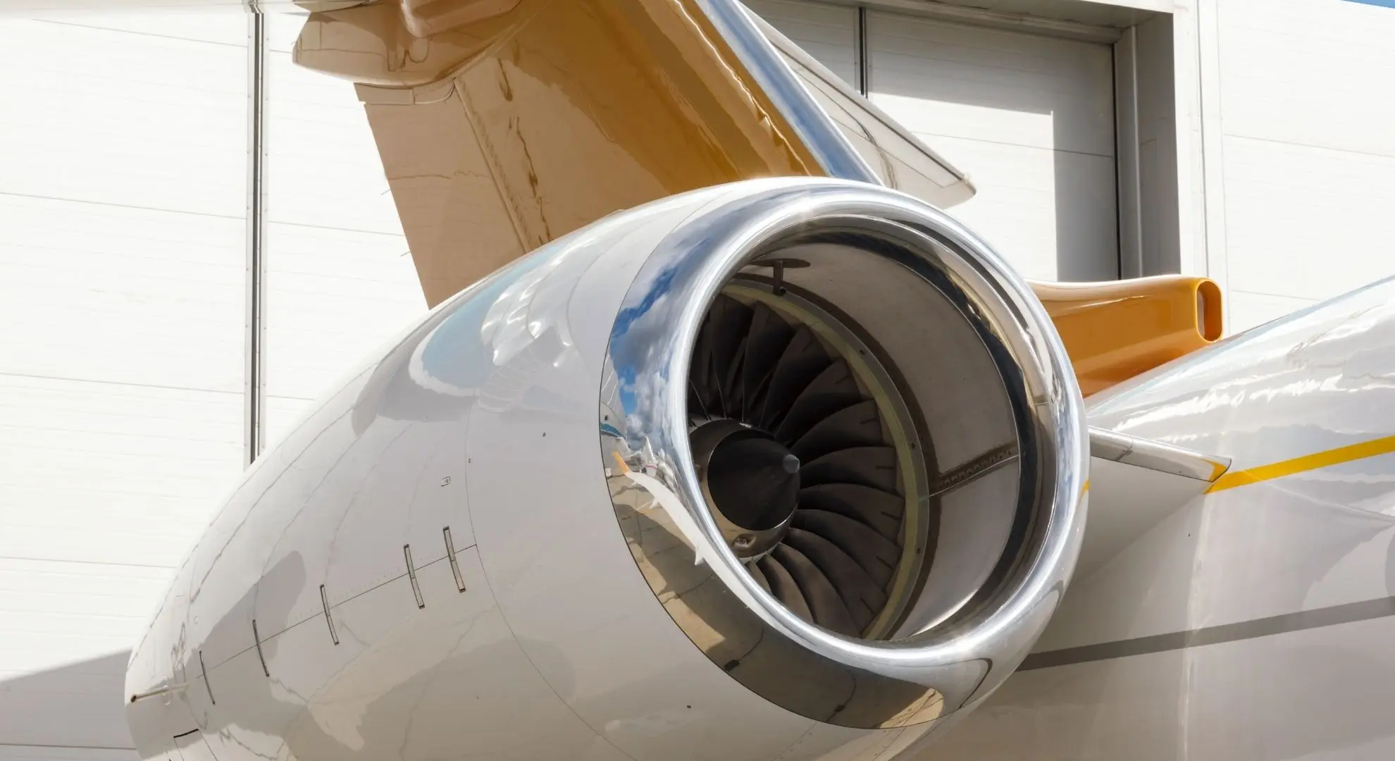 Close-up of a polished private jet turbofan engine in a hangar, showcasing the precision engineering