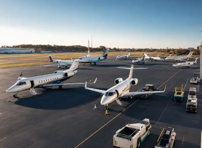 Fleet of private jets parked on an airport apron, showcasing a range of aircraft sizes available for charter across Indonesia