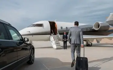 Private Jet for Mining in Indonesia: A Guide to Mining Charter Flights Business traveller walking toward a private jet, greeted by a crew member for a mining charter flight in Indonesia