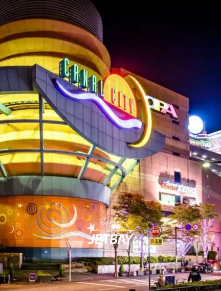 Canal City Hakata shopping complex illuminated at night in Fukuoka, showcasing vibrant neon signage