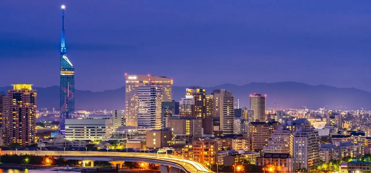 Fukuoka city skyline illuminated at twilight with modern skyscrapers and Fukuoka Tower glowing blue
