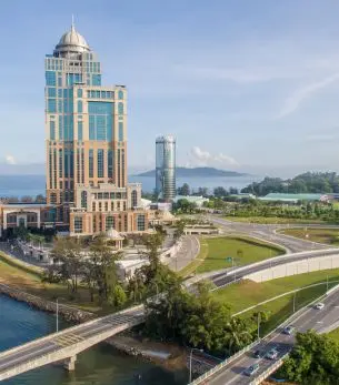 Modern waterfront towers and landscaped grounds showcase Kota Kinabalu's luxury skyline for private jet travelers
