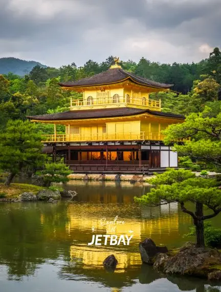 Golden Pavilion temple reflecting in tranquil pond waters surrounded by lush gardens in Kyoto, Japan