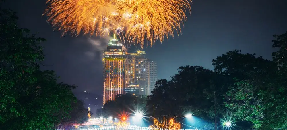 Spectacular fireworks display illuminating luxury hotel towers in Philippines during festive celebration