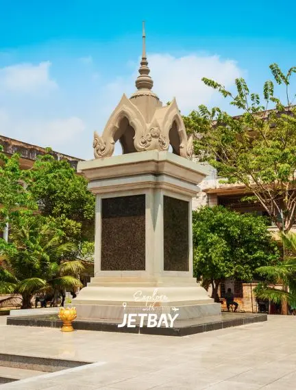 Traditional Cambodian memorial monument with ornate spire surrounded by lush greenery in Phnom Penh