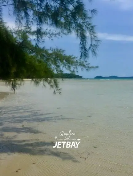 Pristine white sand beach with crystal clear waters and tropical trees in Sihanoukville, Cambodia