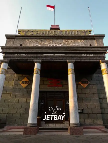 Historic Surabaya monument with classical columns and Indonesian flag showcasing the city's colonial heritage