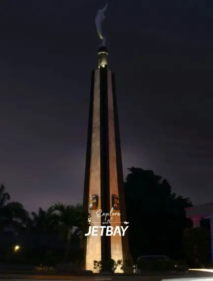 Illuminated Surabaya Heroes Monument towering against twilight sky with Jetbay branding overlay