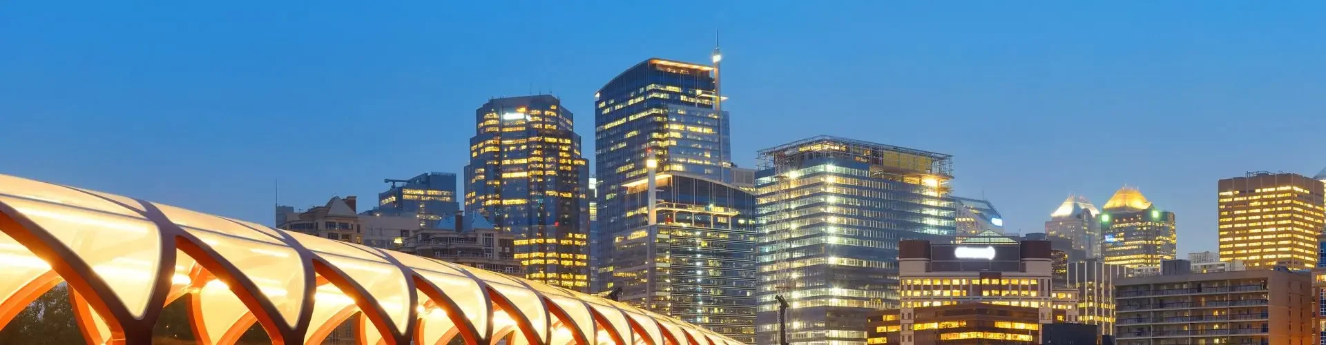 Calgary skyline dusk illuminated peace bridge downtown towers for private jet charter passengers