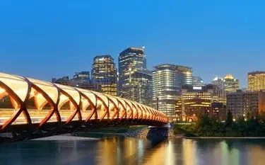 Calgary skyline dusk illuminated peace bridge downtown towers for private jet charter passengers