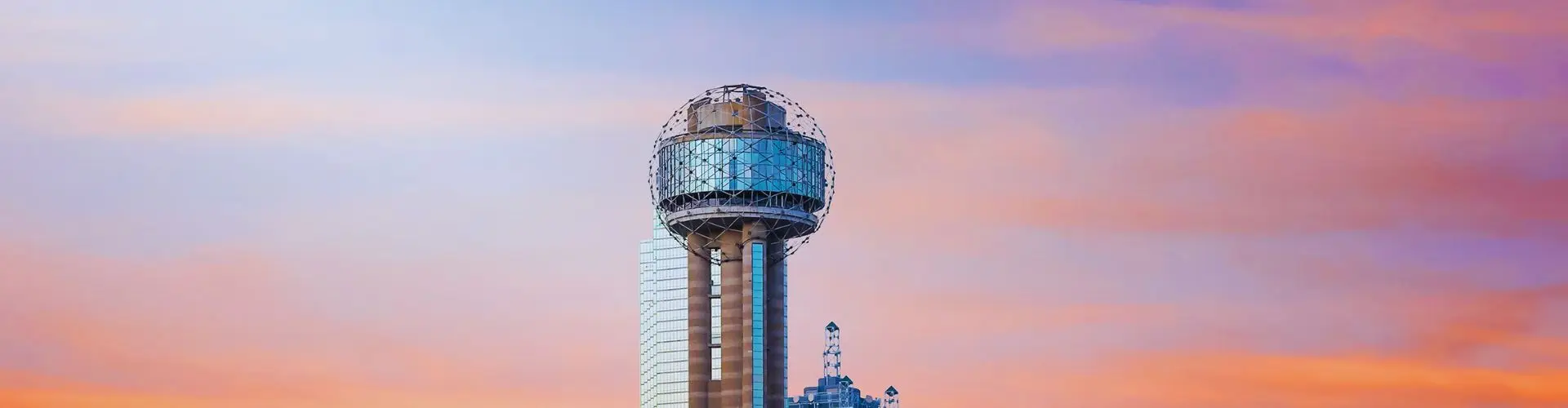 Dallas skyline featuring Reunion Tower at sunset with golden light reflecting off downtown skyscrapers