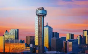 Dallas skyline featuring Reunion Tower at sunset with golden light reflecting off downtown skyscrapers