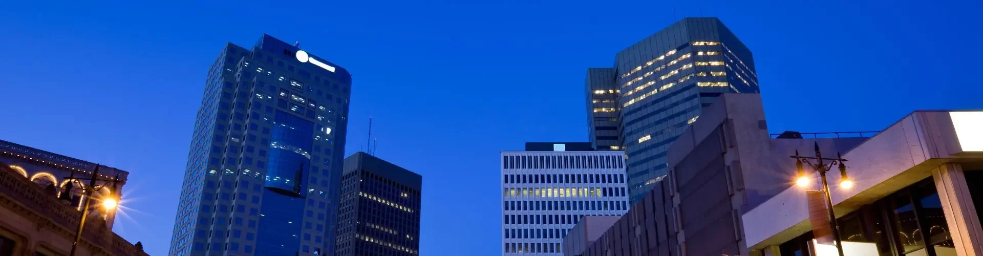 Private Jet Charter from Winnipeg Airport (CYWG) Winnipeg downtown skyline dusk illuminated skyscrapers light trails for private jet charter passengers