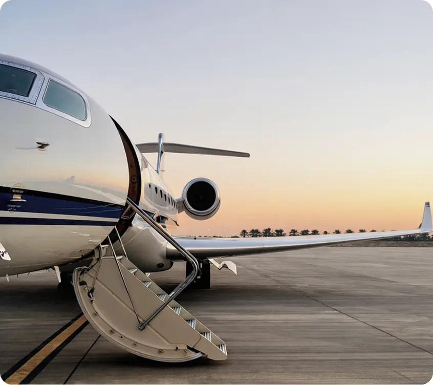 Private jet on the apron in golden-hour light, with its airstair door open and ready for boarding